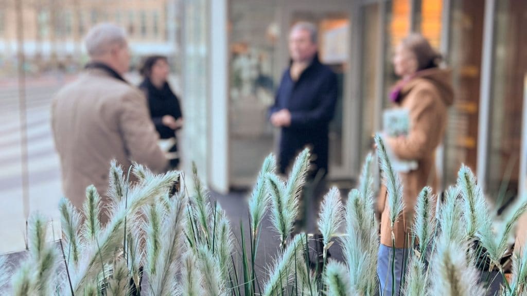 Graspluimen op de voorgrond, gedeputeerden van de Provincie Zuid-Holland en Nico en Thirza van Cirkelstad op de achtergrond