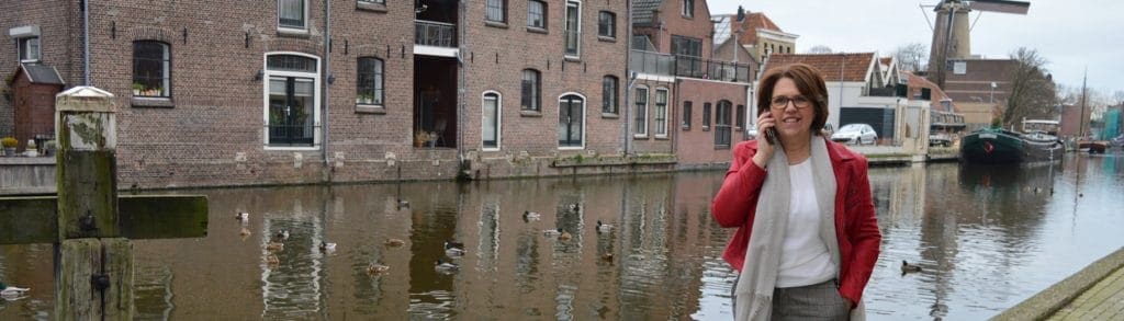 foto van bellende vrouw, ze loopt langs het water, links het logo van platform Groene Hart Werkt!